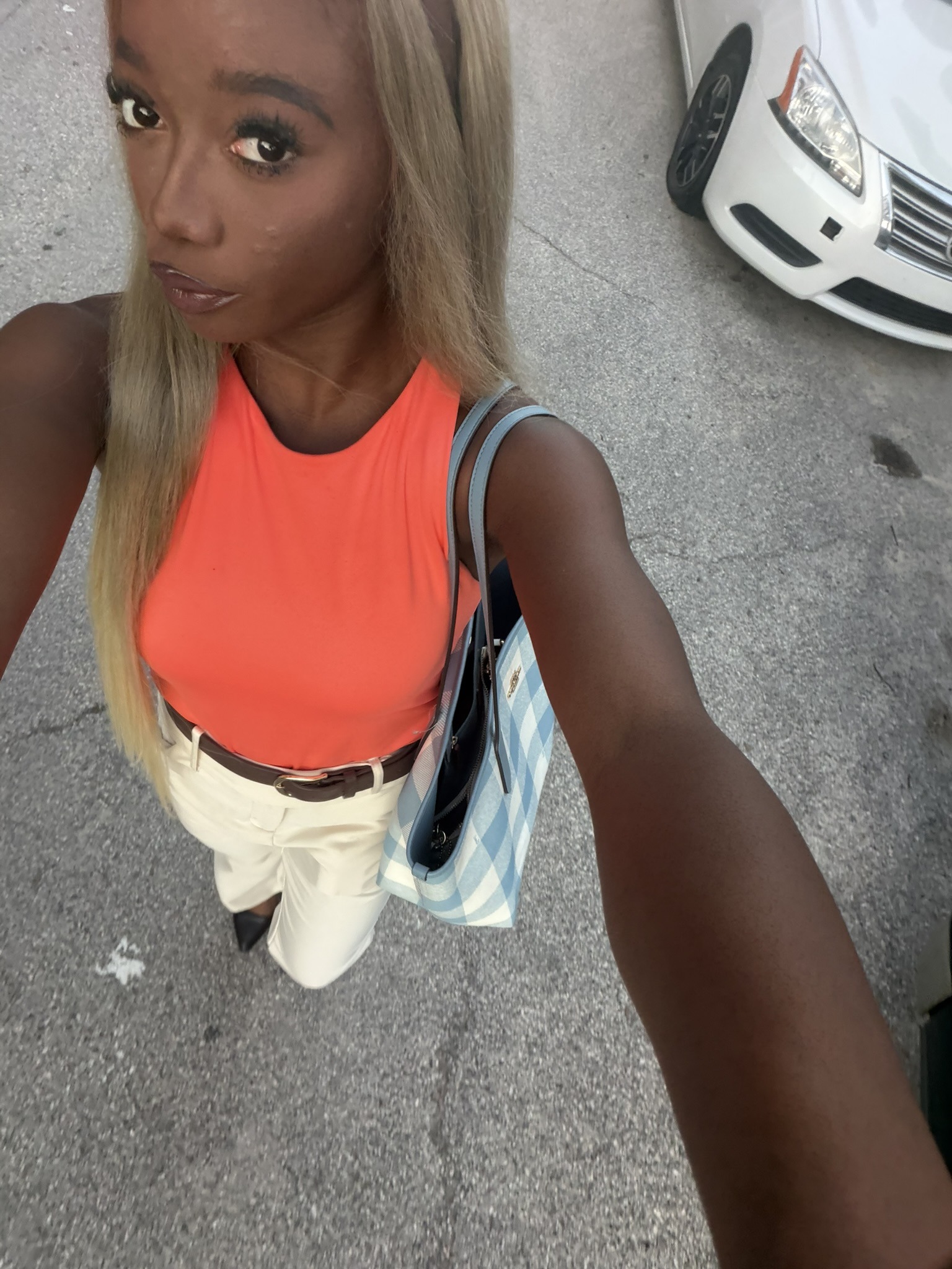 Jaiden in an orange top with a blue gingham bag